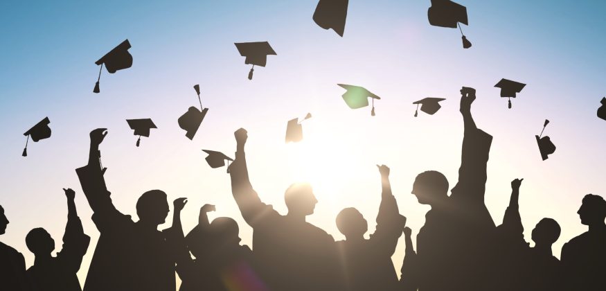 silhouettes of students throwing mortarboards